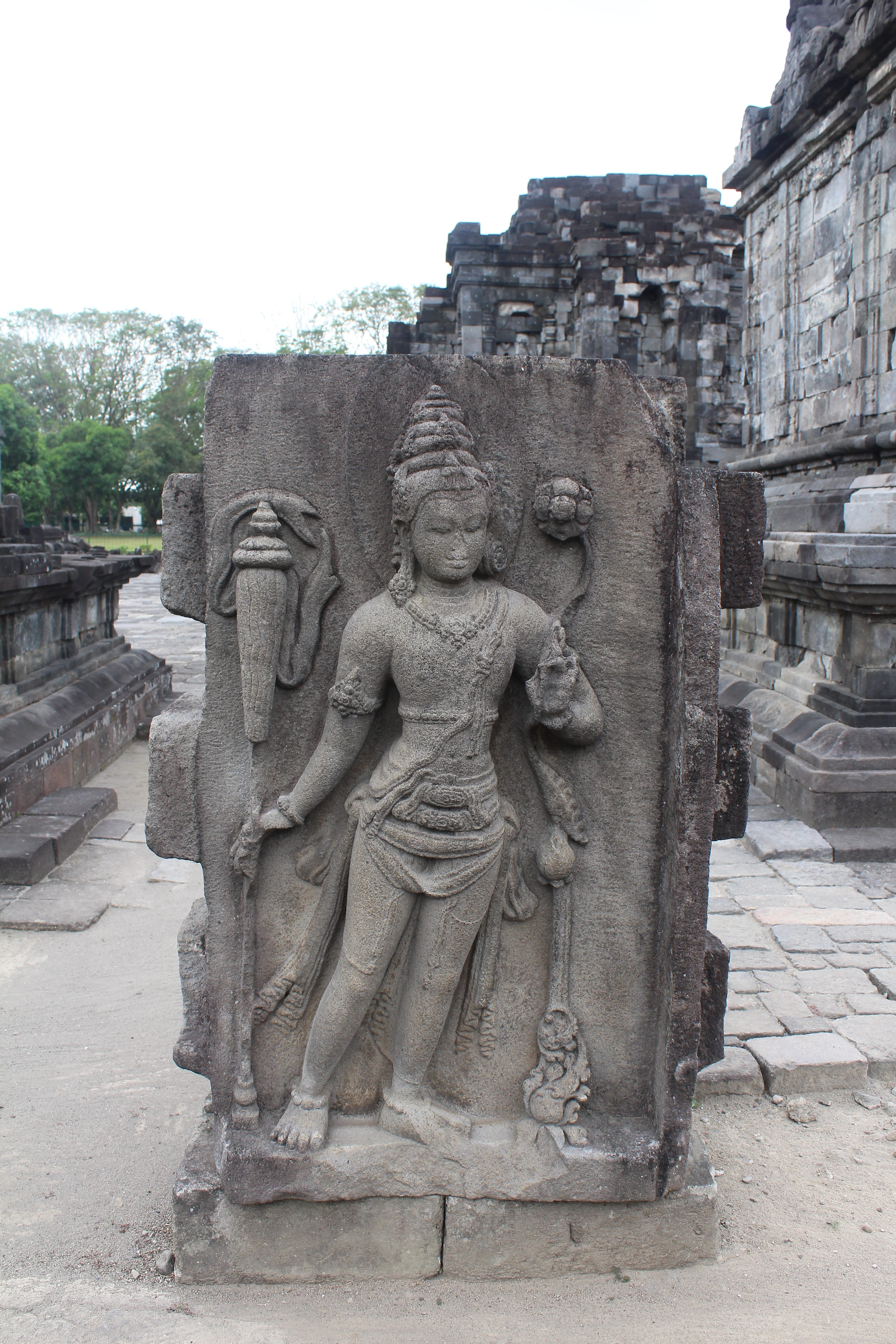 Stone slab with Buddhist figure (Padmapani) carved in relief, in a temple courtyard