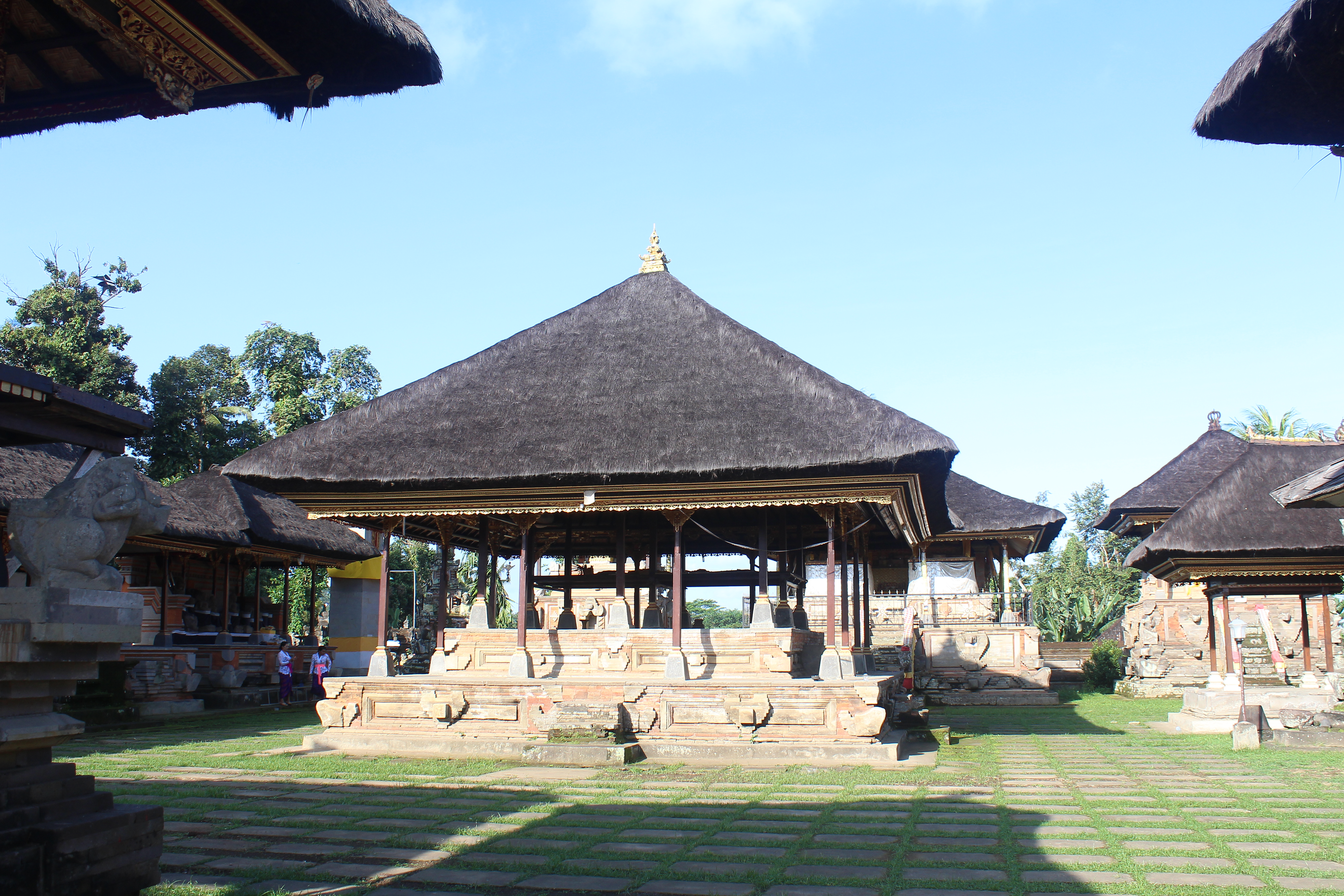 Thatch hut shrine complex with overgrown pavestones