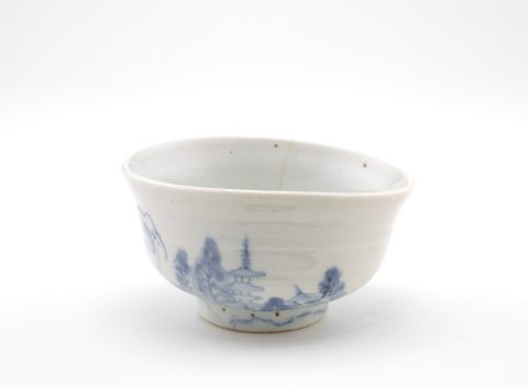 white porcelain bowl with blue design of a pagoda and landscape