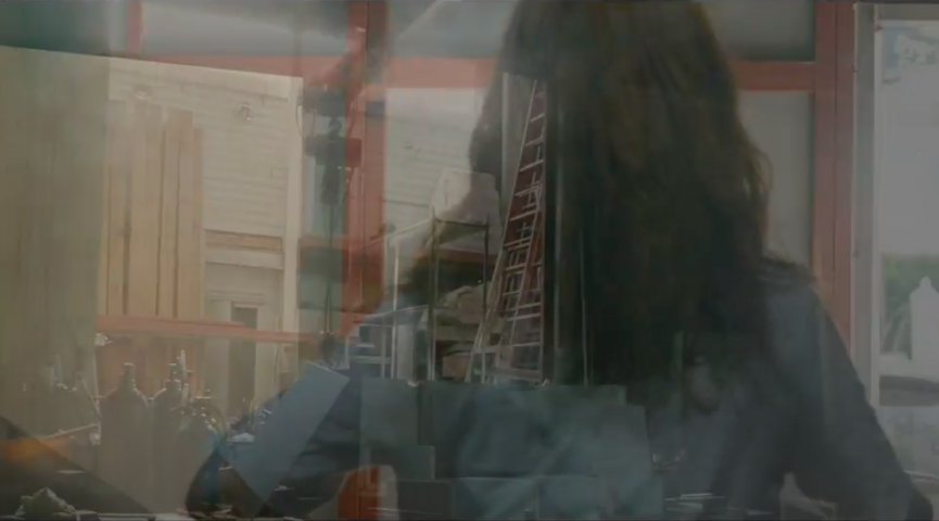 still from video "My Work Place" by Minouk Lim. A composition of images, showing a woman from behind superimposed with structural images