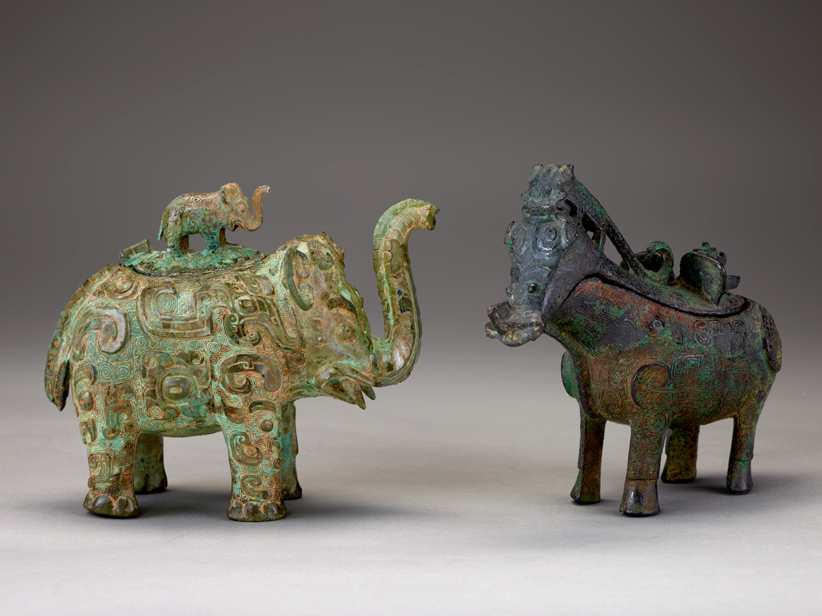 left, a vessel shaped like a small elephant standing on another elephant, on the right, a vessel shaped like a hoofed animal